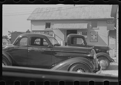 Cars parked beside feed store, Plain City, Ohio, 1938