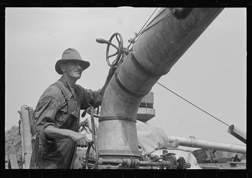 Adjusting straw stacker or grain separator, Ohio, 1938