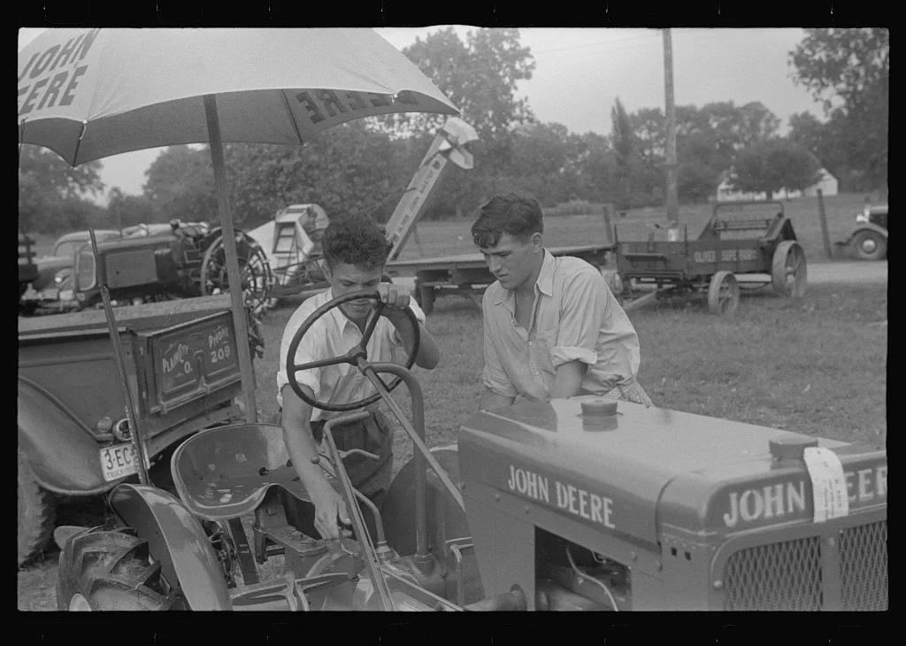 Examining tractor on display at county fair, central Ohio, 1938