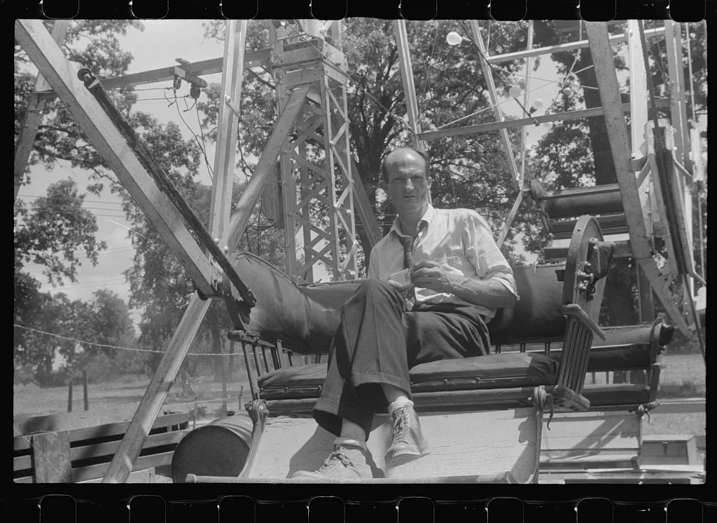 Operator of ferris wheel resting at county fair in central Ohio, 1938